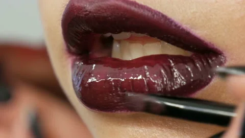 Juicy dark red lips are made up with special brush lipstick and lip gloss, which Stock Footage 115265654