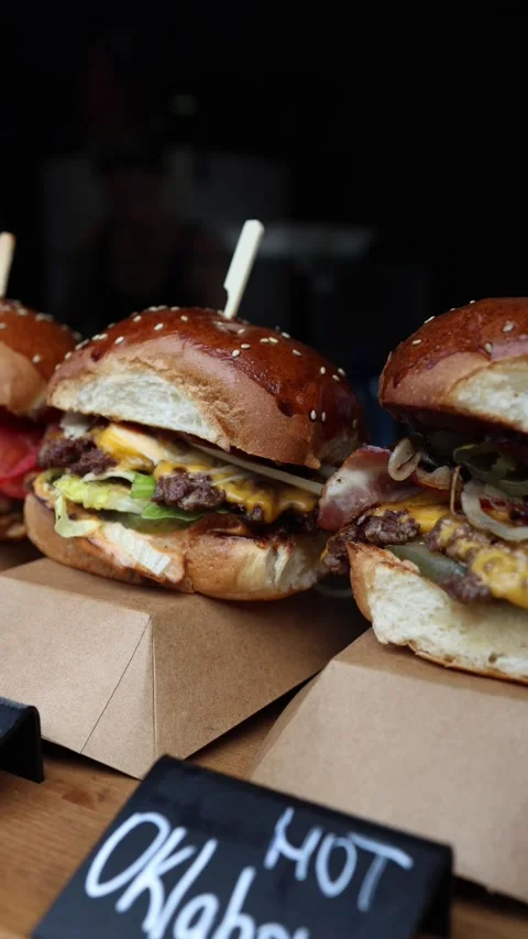 Juicy double cheeseburger with melted cheese and beef patties on a table Vídeo Stock 346973760