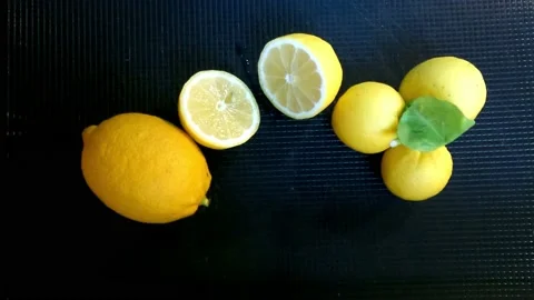 A juicy fresh lemon is cut open to squeeze. Top view. Stock Footage 149376229