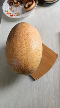 Juicy Fresh Melon Displayed on a Rustic Wooden Cutting Board for Everyone to Stock Photos