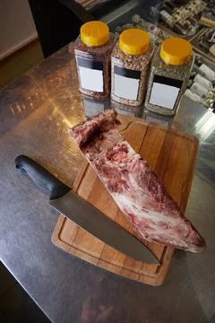 Juicy Fresh piece of meat on the table chef cuts with a knife spices and Stock Photos