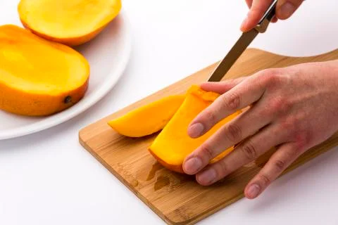 Juicy fruit chip being sliced off a mango third Stock Photos