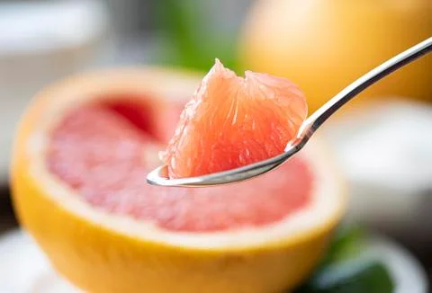 Juicy grapefruit pulp on a teaspoon Stock Photos