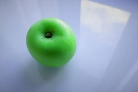 Juicy green Apple on a gray glass background Stock Photos