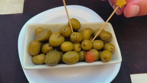 Juicy green olives with beer on a table at a street cafe terrace. Tapas an Stock Footage 320560744