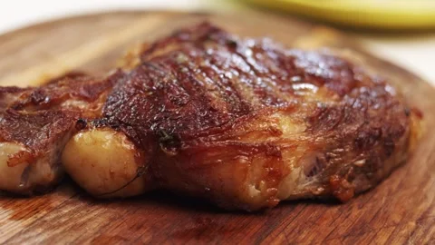 Juicy grilled beef steak with herbs on a wooden board Vidéo 340563378