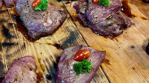 Juicy Grilled Beef Steaks Displayed on Wooden Board at Street Food Market Stock Footage 337227344
