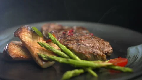 Juicy hot beef steak with cooked mushrooms and asparagus is rotating slowly Stock Footage 157843188