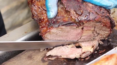 Juicy joint of meet being carved at a BBQ Stock Footage 80436370