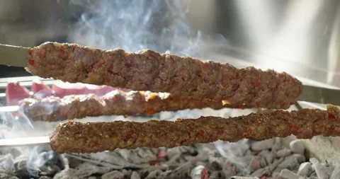 Juicy kebab and vegetables roasting on barbecue charcoal grill. Chef flips kebab Stock Footage 274576053