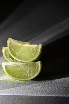 Juicy Lime Wedges with Dramatic Direct Light and Rays Shadow Effect Stock Photos