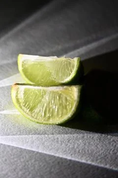 Juicy Lime Wedges with Dramatic Direct Light and Rays Shadow Effect Stock Photos