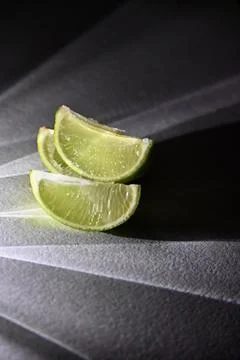 Juicy Lime Wedges with Dramatic Direct Light and Rays Shadow Effect Stock Photos