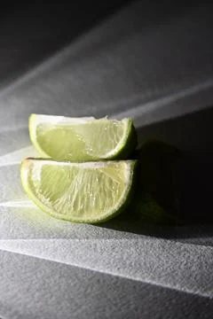 Juicy Lime Wedges with Dramatic Direct Light and Rays Shadow Effect Stock Photos