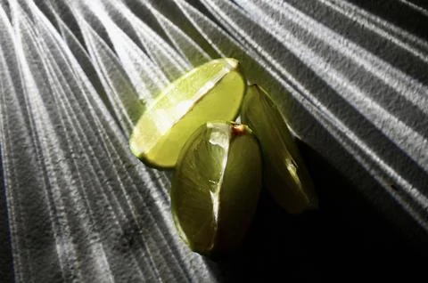 Juicy Lime Wedges with Dramatic Direct Light and Rays Shadow Effect Stock Photos