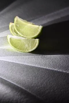Juicy Lime Wedges with Dramatic Direct Light and Rays Shadow Effect Stock Photos
