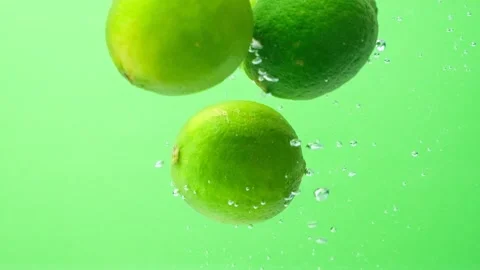 Juicy Limes Dropped Into Water. Bubble Explosion Scene Stock Footage 312213628