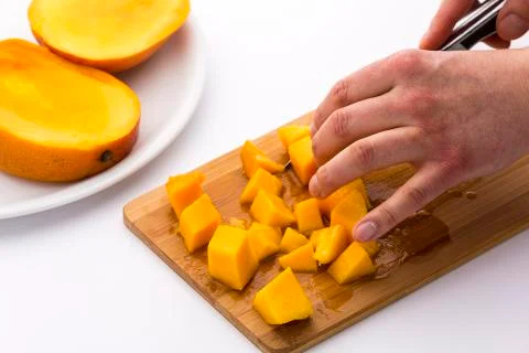 Juicy mango fruit pulp diced on a kitchen board Stock Photos