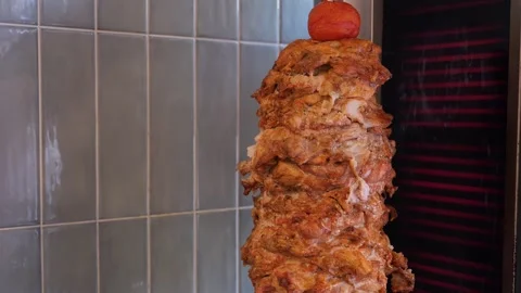 Juicy meat is fried on a shawarma spit. Stock Footage 319004509