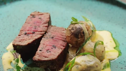 Juicy medium Beef Meat Rib Eye steak slices with baked potato in expensive Stock Footage 261771055