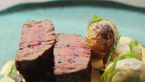 Juicy medium Beef Meat Rib Eye steak slices with baked potato in expensive Stock Footage 266818855