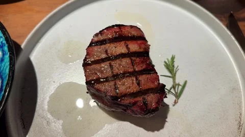 Juicy medium rare beef steak served on a plate with rosemary. Grilled meat Stock Footage 334719727