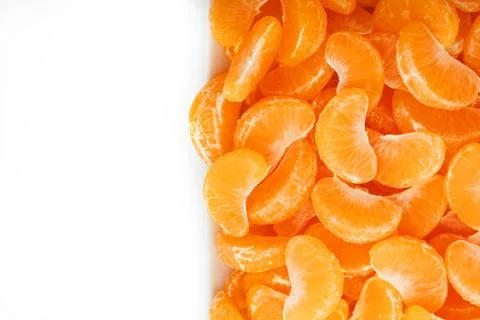 Juicy orange slices of MANDARIN in a rectangular white plate on a white backg Foto stock