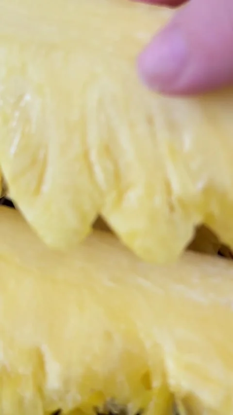 Juicy pieces of slice ripe pineapple stand on a plate on the table a female hand Stock Footage 308810248