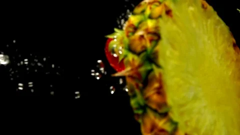 Juicy pineapple, red currant strawberry dropped into the water Video stock 77748998