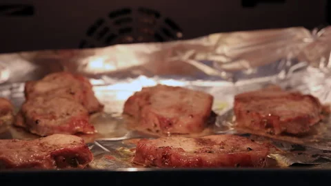Juicy Pork Chops Baking On Foil In An Oven Close-Up Stock-Footage 294042796