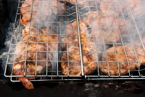 Juicy pork steak cooking on an open flame grill. Stock Photos
