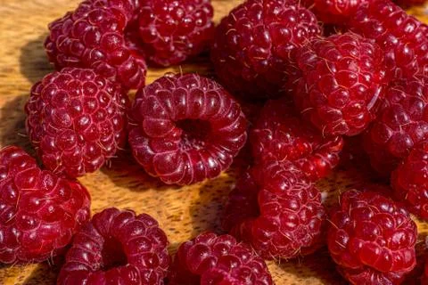 Juicy raspberry close up macro on a wood background. Nature background. Fresh Stock Photos