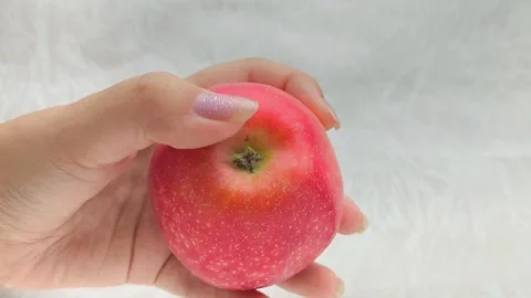 A juicy red apple with a green leaf in a womans hand. Juicy fruits. Stock Footage 314976413