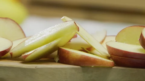 Juicy red apple slices on cutting board - closeup panning shot Stock Footage 341251333