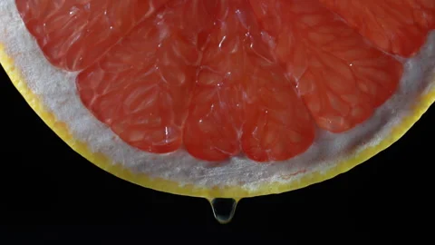 Juicy red grapefruit slice with drop on black background . Fresh citrus fruit Stock Footage 297252261