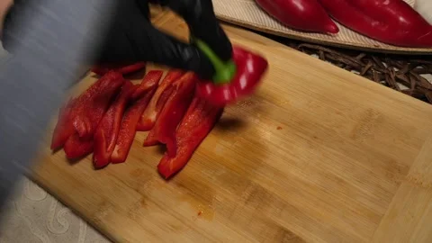 Juicy Red Pepper Cut by Hand on Wooden Surface Stock Footage 311894486