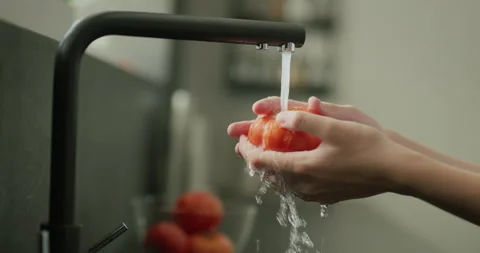 Juicy red tomato is washed under water from the kitchen tap. Slow motion 4k Stock-Footage 251383520