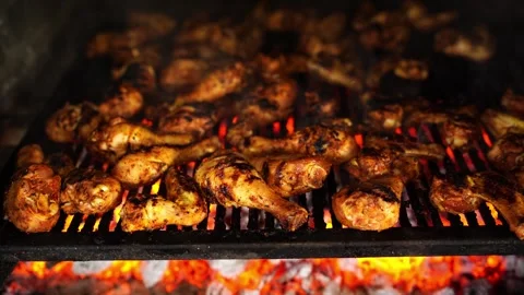 Juicy ribs emit smoke while roasting on a grill in a charcoal oven Stock Footage 287666260