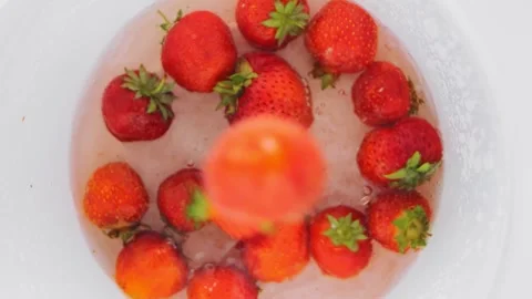 Juicy ripe red strawberries fall into a container of water. 库存影片 248780204