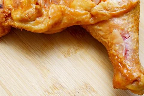 Juicy roasted chicken leg resting on a wooden cutting board in a cozy kitch.. Stock Photos