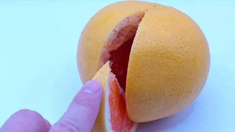 A juicy slice of grapefruit in hands 動画素材 331746447