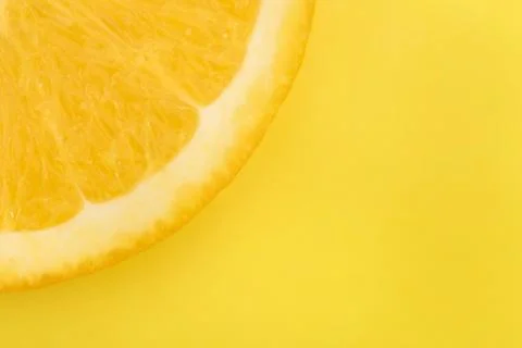Juicy slice of lemon on a yellow background Stock Photos