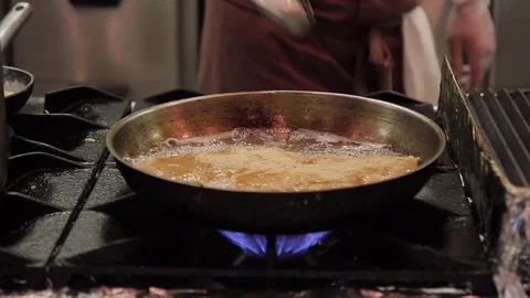 Juicy steak is fried in deep fat in a pan on kitchen of restaurant. Stock Footage 76808429