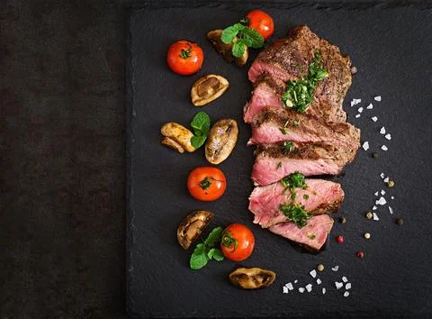 Juicy steak medium rare beef with spices and grilled vegetables. Top view Stock Photos