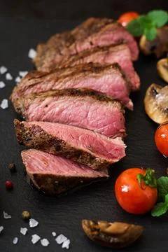 Juicy steak medium rare beef with spices and grilled vegetables. Stock Photos