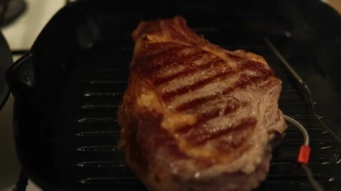 Juicy steak seared on a cast iron grill pan with temperature probe Stock Footage 340562825