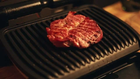 Juicy steak sizzling on a hot electric grill with sear marks Vidéo 340562995