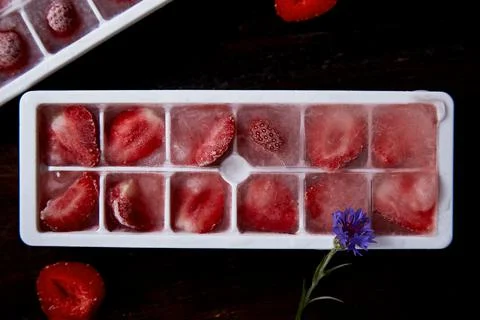 Juicy strawberry ice in the forms close up. Preparing ice for cocktail, ice Stock Photos
