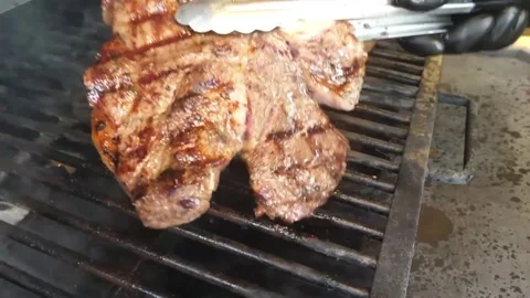Juicy T-bone Steaks Grilling on a Barbecue with Smoke and Char Marks [1, 2] Stock Footage 338213210