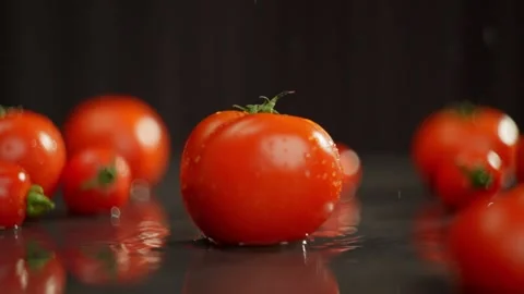 A juicy tomato falls slowly on the table on a beautiful background. Stock Footage 270156947
